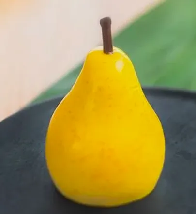 Yellow pear trompe-l'œil entremets with mirror glaze on a black plate